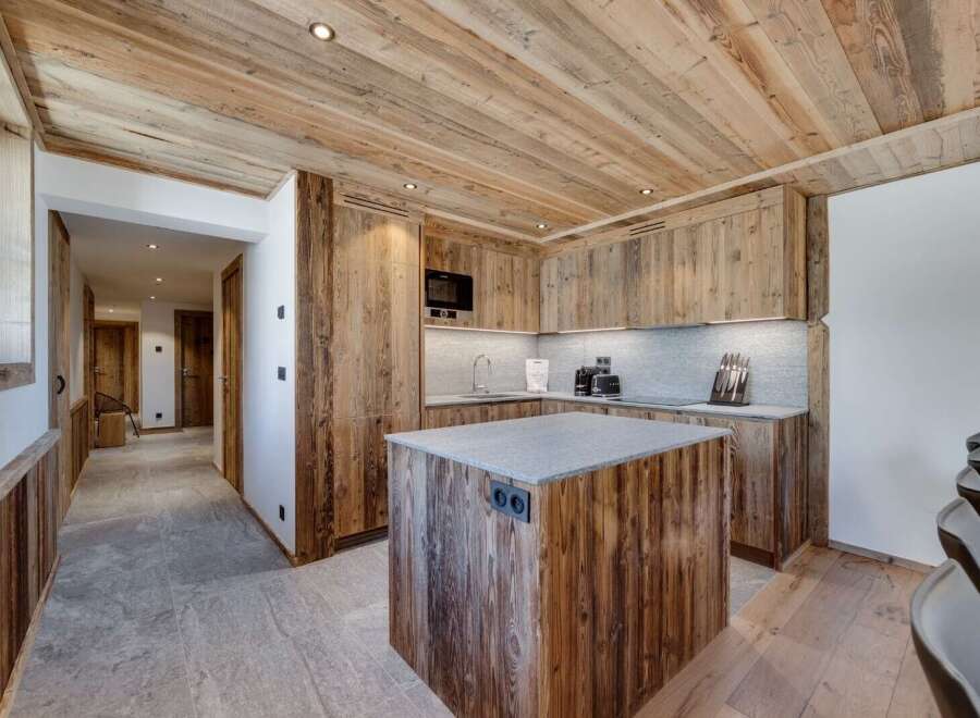 This stunning chalet boasts a rustic-chic kitchen with reclaimed wood cabinetry and a granite island, perfect for culinary adventures.