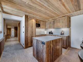 This stunning chalet boasts a rustic-chic kitchen with reclaimed wood cabinetry and a granite island, perfect for culinary adventures.