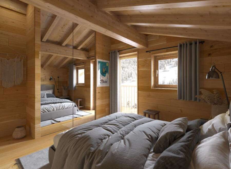 Cozy chalet bedroom with wooden walls and beams, featuring a comfortable bed with gray linens and a mirrored closet.