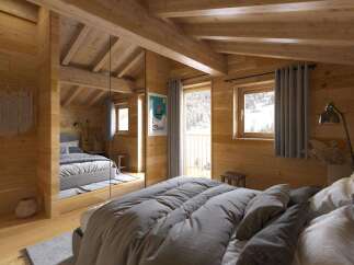 Cozy chalet bedroom with wooden walls and beams, featuring a comfortable bed with gray linens and a mirrored closet.