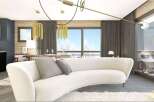 Stunning apartment boasts a modern, open-plan living area with a curved sofa and large windows offering breathtaking views.