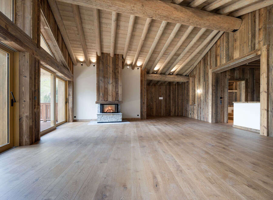 Experience rustic luxury in this stunning mountain chalet featuring a grand fireplace and exposed wooden beams.