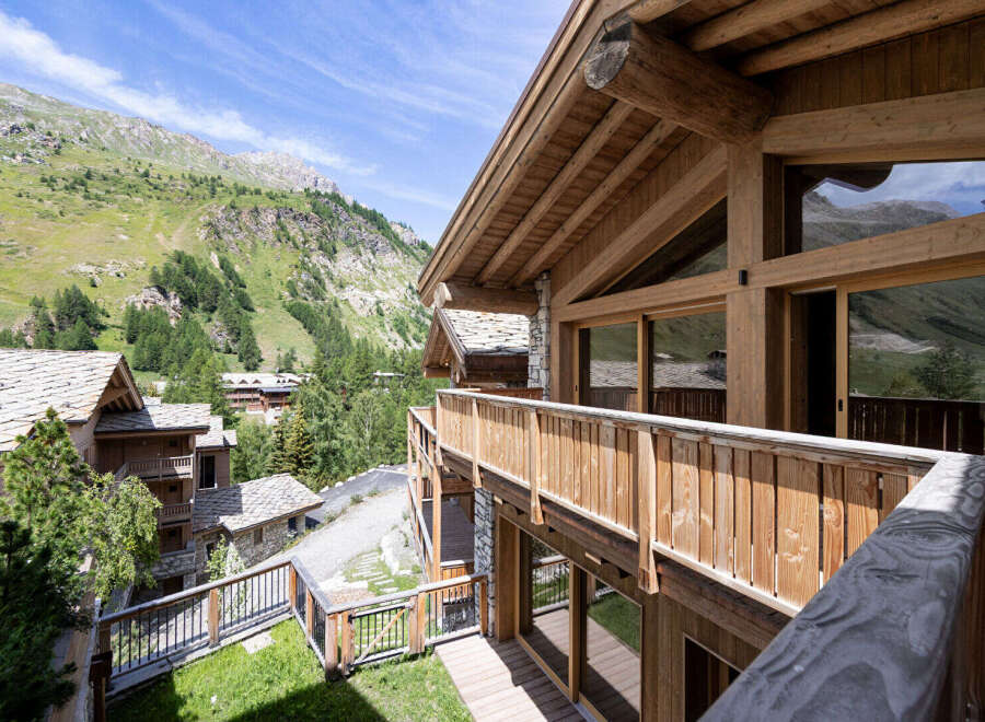 Experience breathtaking mountain views from this stunning wooden chalet, featuring expansive windows and a spacious balcony perfect for enjoying the alpine scenery.