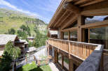 Experience breathtaking mountain views from this stunning wooden chalet, featuring expansive windows and a spacious balcony perfect for enjoying the alpine scenery.