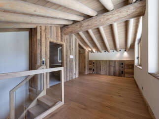 Experience rustic charm in this beautifully appointed room featuring exposed wooden beams and natural wood paneling throughout.