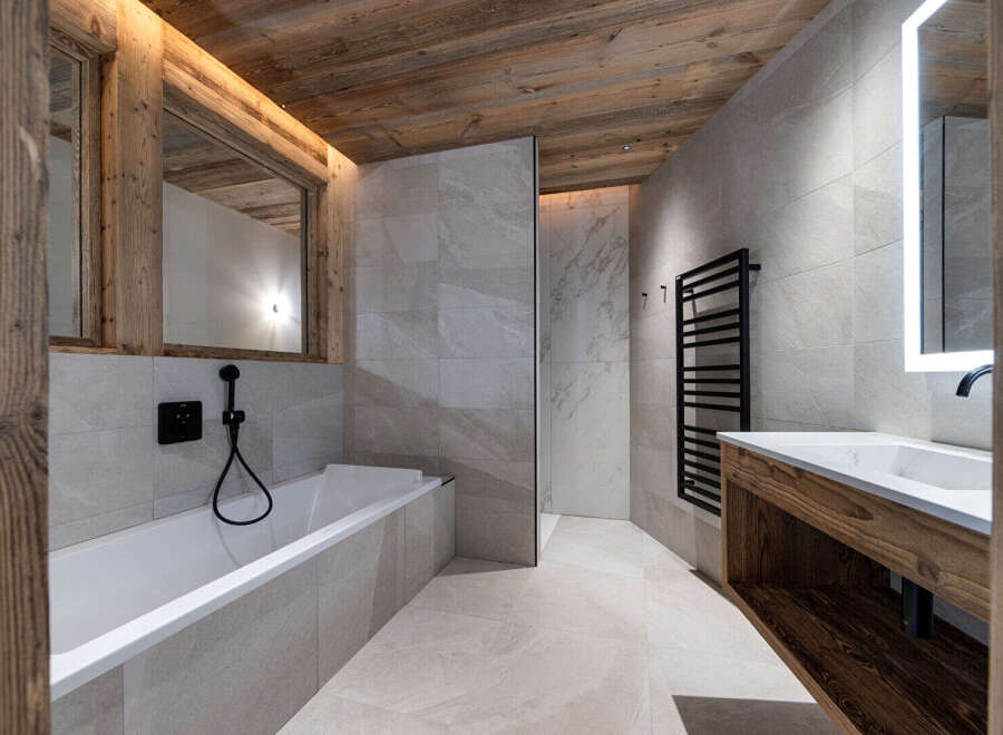 Experience luxury mountain living in this stunning bathroom featuring a deep soaking tub and a sleek vanity with a modern sink.