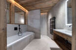 Experience luxury mountain living in this stunning bathroom featuring a deep soaking tub and a sleek vanity with a modern sink.