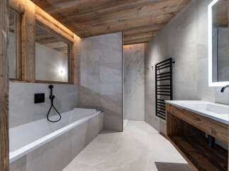 Experience luxury mountain living in this stunning bathroom featuring a deep soaking tub and a sleek vanity with a modern sink.