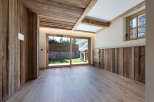 Experience rustic charm and modern comfort in this beautifully appointed room, featuring natural wood paneling on the walls and ceiling, complemented by a light wood floor.