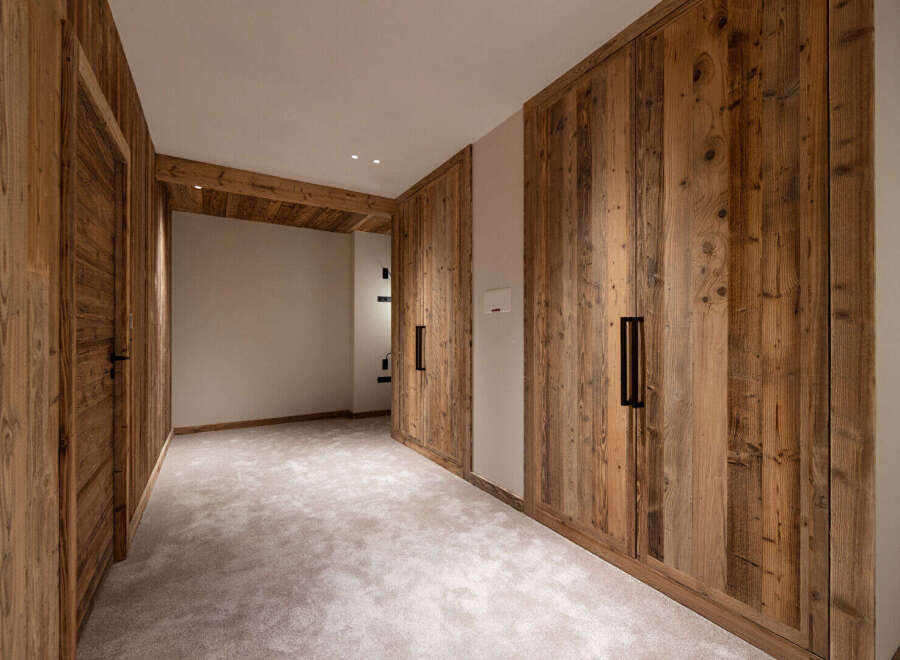 Experience rustic charm and modern convenience in this beautifully appointed room featuring custom wooden cabinetry and a plush carpeted floor.