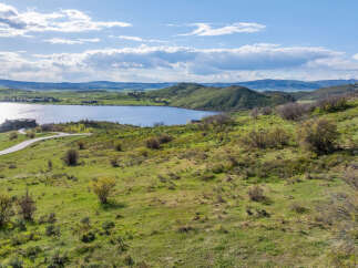 This stunning property boasts breathtaking views of a serene lake nestled in a picturesque valley.