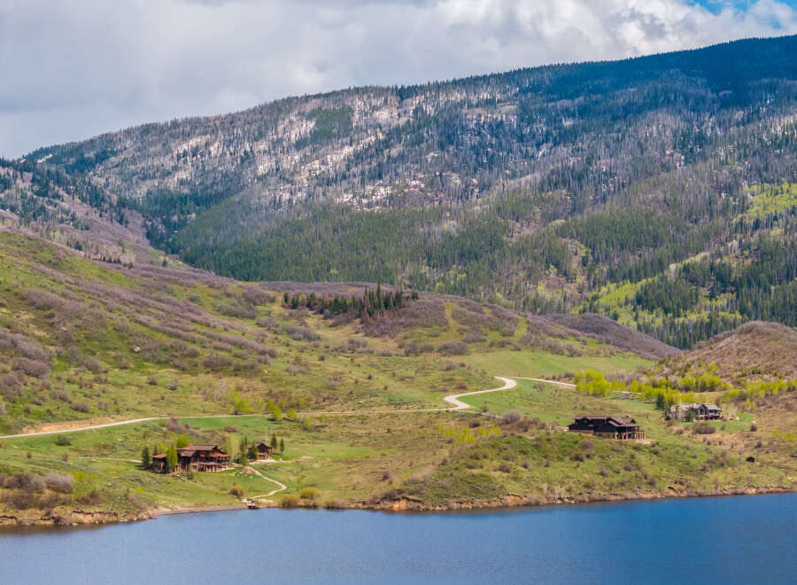 Luxury mountain homes nestled on a tranquil lake, offering breathtaking views and serene surroundings.