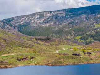 Luxury mountain homes nestled on a tranquil lake, offering breathtaking views and serene surroundings.