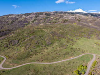 This stunning property boasts a scenic, winding road leading to breathtaking views of the mountain landscape.