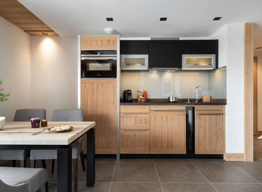 This stunning apartment boasts a modern, fully equipped kitchen with sleek wooden cabinetry and integrated appliances.
