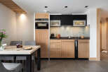 This stunning apartment boasts a modern, fully equipped kitchen with sleek wooden cabinetry and integrated appliances.