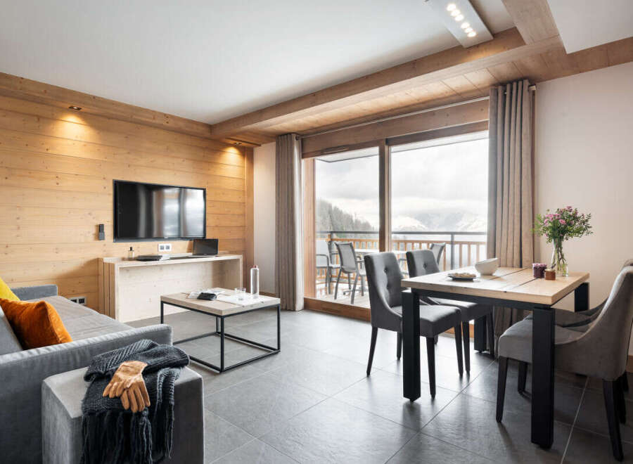 This stunning apartment boasts a spacious open-plan living area with floor-to-ceiling windows offering breathtaking mountain views.