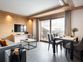 This stunning apartment boasts a spacious open-plan living area with floor-to-ceiling windows offering breathtaking mountain views.