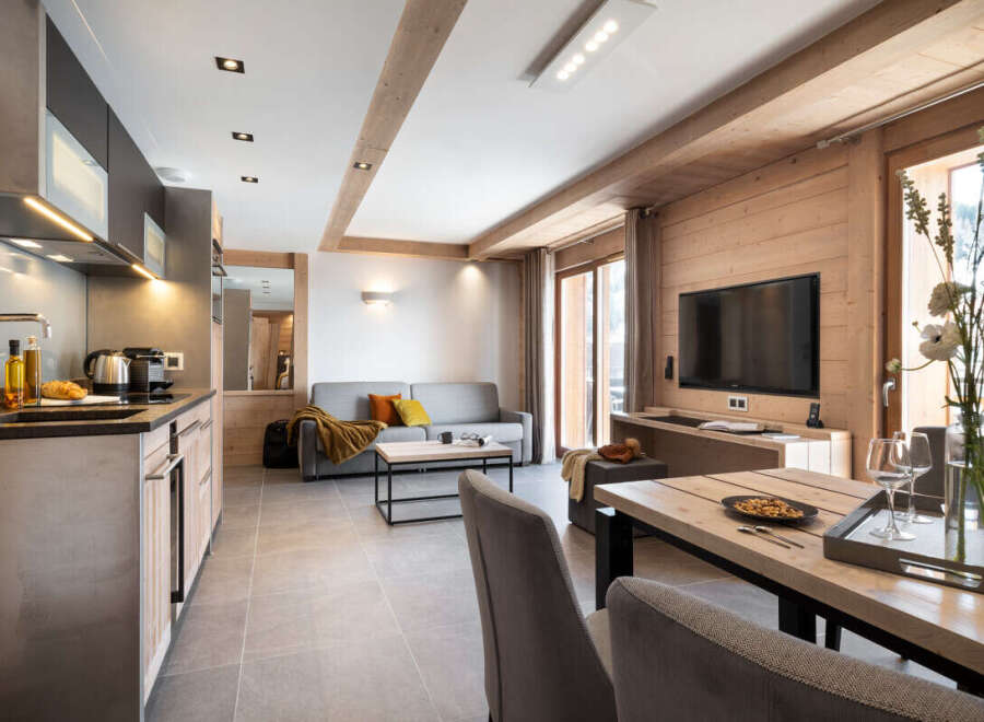 This stunning apartment boasts an open-plan living area with a modern kitchen, plush sofa, and a large dining table perfect for entertaining.