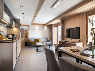 This stunning apartment boasts an open-plan living area with a modern kitchen, plush sofa, and a large dining table perfect for entertaining.