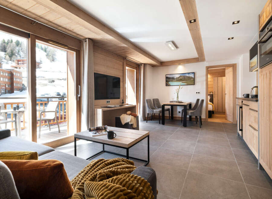 This stunning apartment boasts a spacious living area with floor-to-ceiling windows offering breathtaking mountain views, a fully equipped kitchen, and modern amenities.