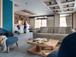 Relax in our stylish lobby, featuring comfortable seating, a coffee table with magazines, and a modern reception desk.