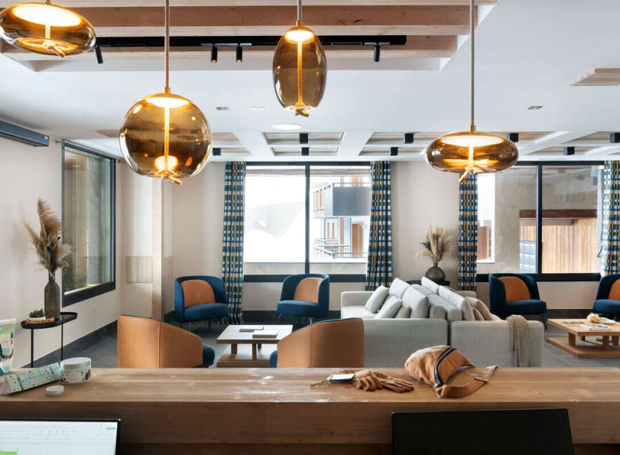This stunning lobby boasts a cozy and inviting atmosphere, featuring plush seating arrangements and stylish pendant lights.