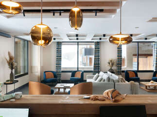 This stunning lobby boasts a cozy and inviting atmosphere, featuring plush seating arrangements and stylish pendant lights.