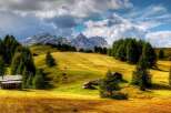 Discover the breathtaking beauty of this mountain landscape, featuring charming wooden cabins nestled amidst rolling hills.