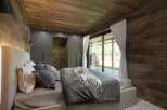 Experience luxury in this stunning bedroom featuring a modern design with wooden accents.