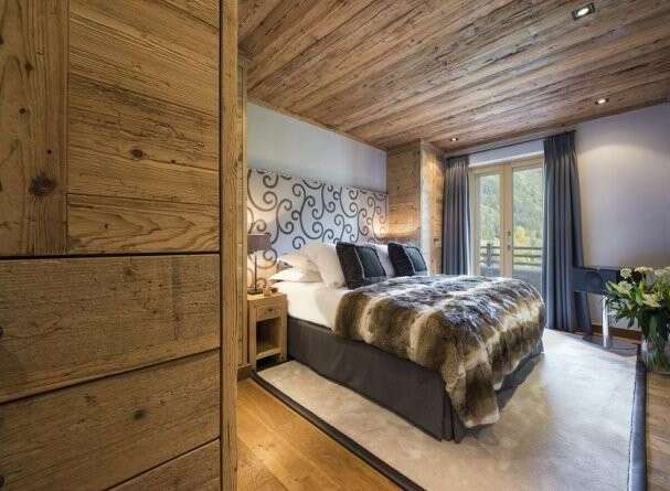 Experience luxury in this stunning bedroom featuring a cozy fur blanket and elegant headboard.