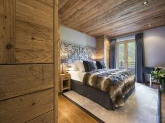 Experience luxury in this stunning bedroom featuring a cozy fur blanket and elegant headboard.