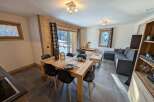 This stunning apartment boasts an open-plan living area with a cozy seating arrangement and a spacious dining table perfect for family meals.