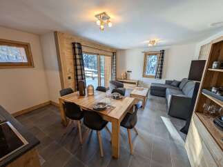 This stunning apartment boasts an open-plan living area with a cozy seating arrangement and a spacious dining table perfect for family meals.