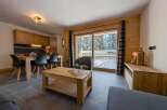 This stunning apartment boasts a spacious open-plan living area with floor-to-ceiling windows offering breathtaking views of the snowy landscape.