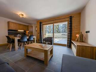 This stunning apartment boasts a spacious open-plan living area with floor-to-ceiling windows offering breathtaking views of the snowy landscape.