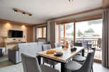 This stunning apartment boasts a spacious open-plan living area with floor-to-ceiling windows offering breathtaking views of the snowy mountains.