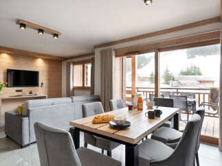 This stunning apartment boasts a spacious open-plan living area with floor-to-ceiling windows offering breathtaking views of the snowy mountains.
