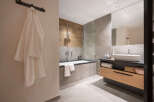 This luxurious bathroom boasts a spacious bathtub, a sleek modern sink, and plenty of storage.