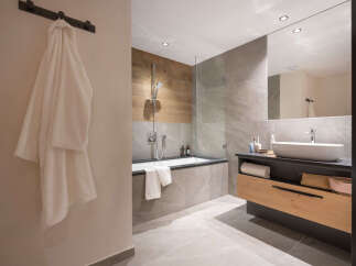 This luxurious bathroom boasts a spacious bathtub, a sleek modern sink, and plenty of storage.
