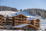 Luxury chalet-style hotel nestled in a stunning snow-covered mountain setting.