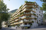 Discover luxury living in this stunning eco-friendly apartment building, nestled in a mountainside setting.