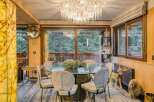 This stunning dining room boasts a glass-top table surrounded by six uniquely designed chairs, creating an elegant and modern ambiance.