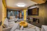 This luxurious living room boasts a stunning onyx feature wall, a modern fireplace, and comfortable gray sofas.