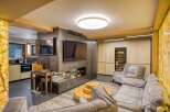 This stunning living room boasts a unique blend of rustic and modern design, featuring a sleek metal media wall with a built-in fireplace and a large flat-screen TV.
