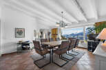 This stunning property boasts a spacious dining area with a large wooden table, modern chairs, and a beautiful chandelier, perfect for entertaining guests.