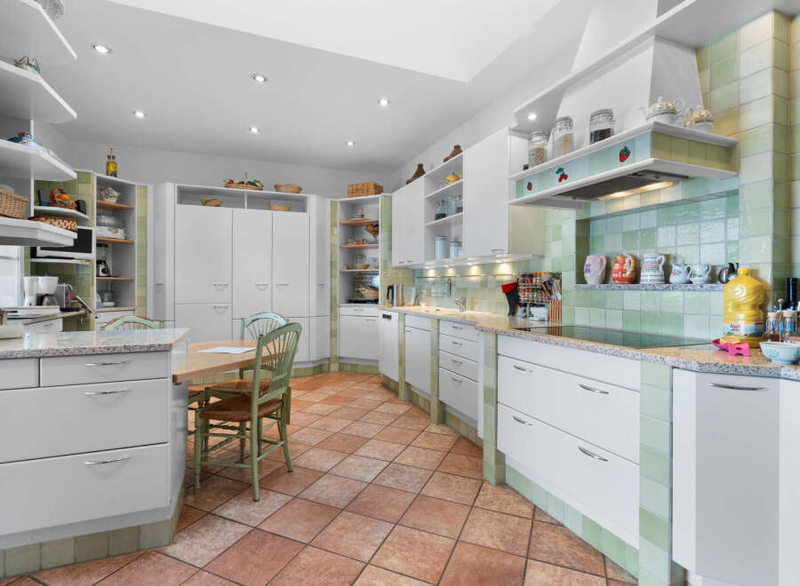 This stunning kitchen boasts a spacious layout with ample cabinetry and counter space, perfect for culinary enthusiasts.