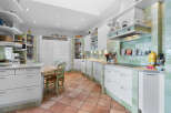 This stunning kitchen boasts a spacious layout with ample cabinetry and counter space, perfect for culinary enthusiasts.