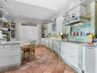 This stunning kitchen boasts a spacious layout with ample cabinetry and counter space, perfect for culinary enthusiasts.