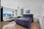 This stunning bedroom boasts breathtaking mountain views from its large windows, creating a serene and relaxing atmosphere.